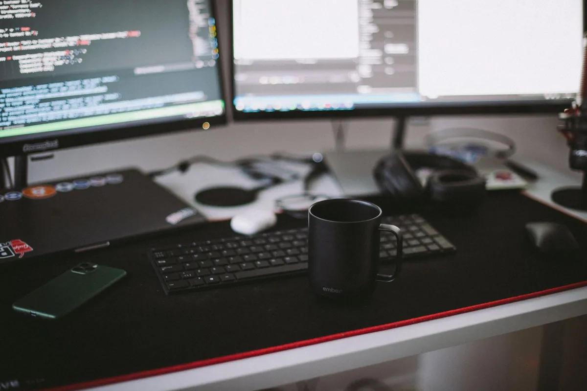 A developer working with application code and connected software tools on a desktop computer.