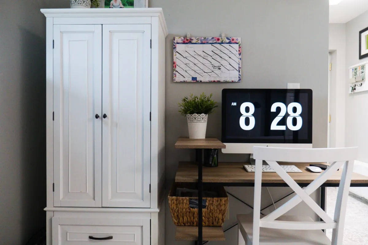 A wall calendar with a date circled in pen, hanging above a tidy desk with a laptop.
