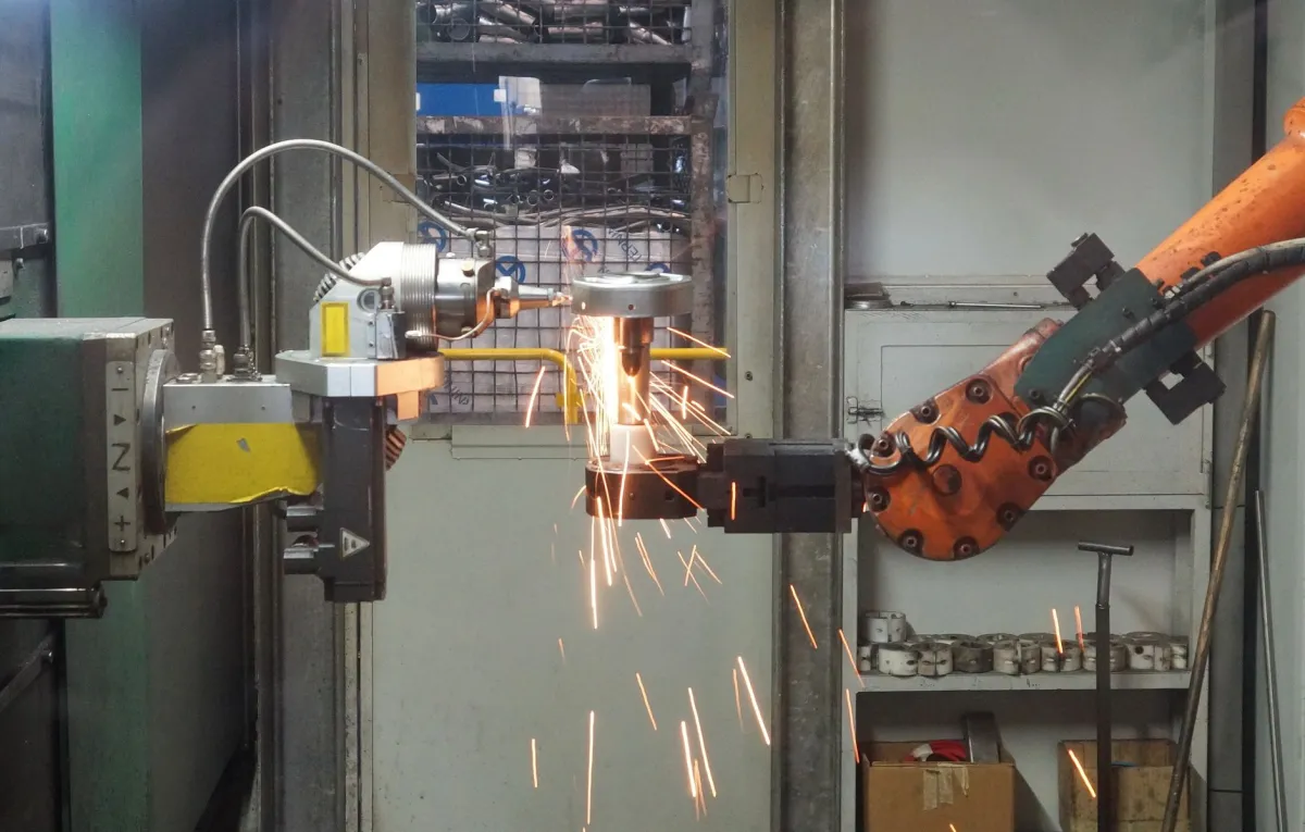 An industrial robotic arm handling components on an automated factory assembly line.