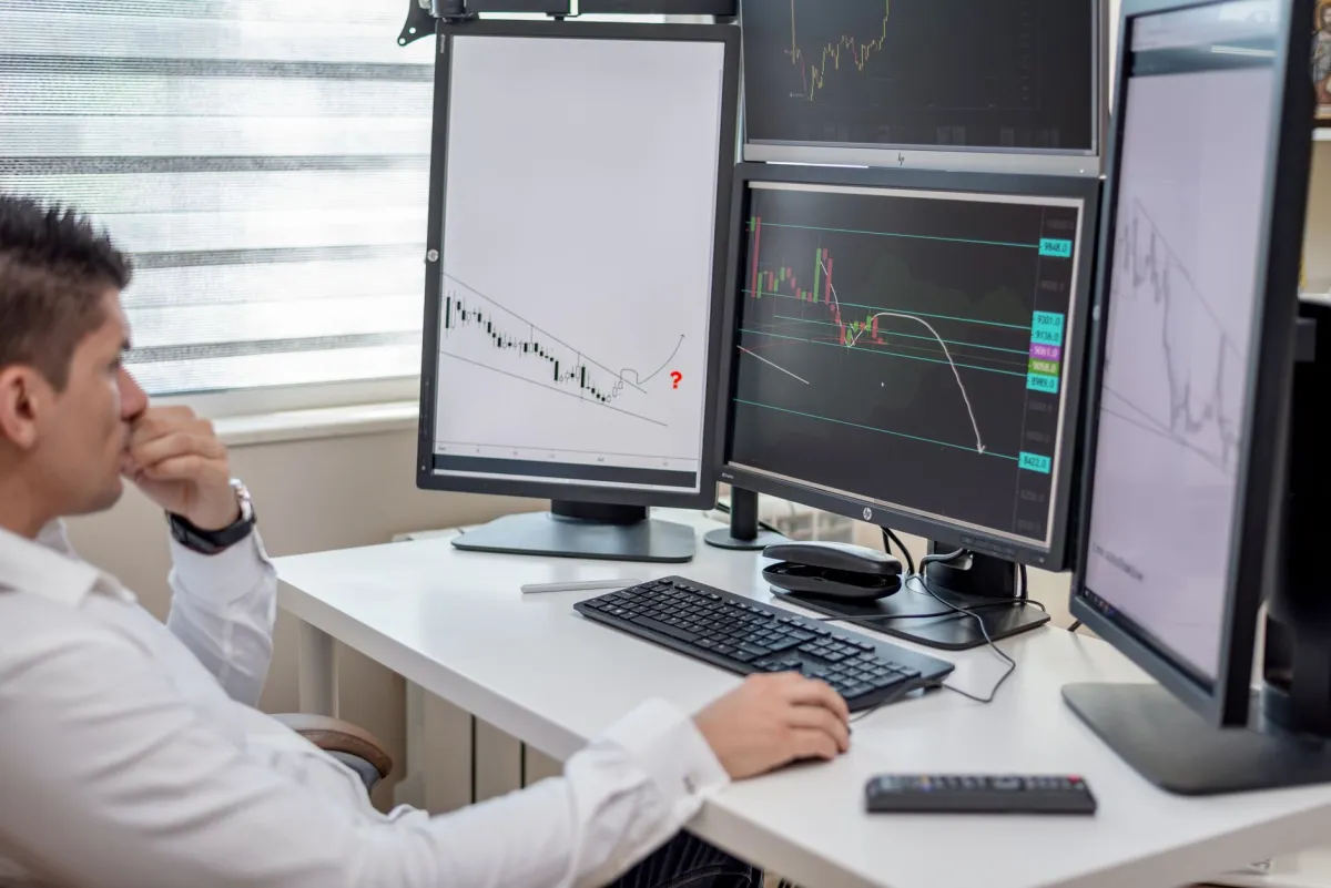 Financial professionals reviewing company performance and investment information at computer workstations.