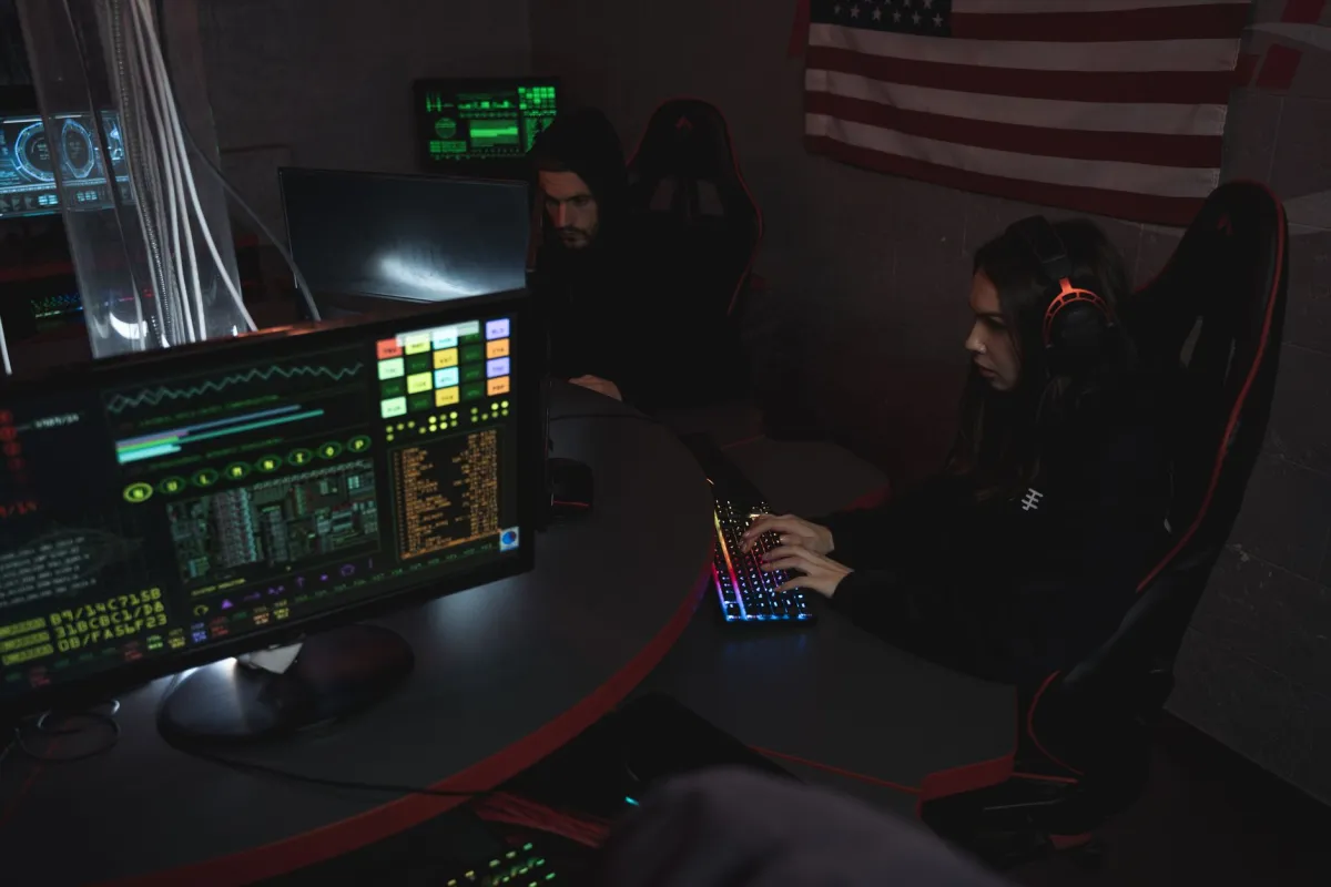 Security specialists reviewing network activity on computer monitors inside an operations centre.
